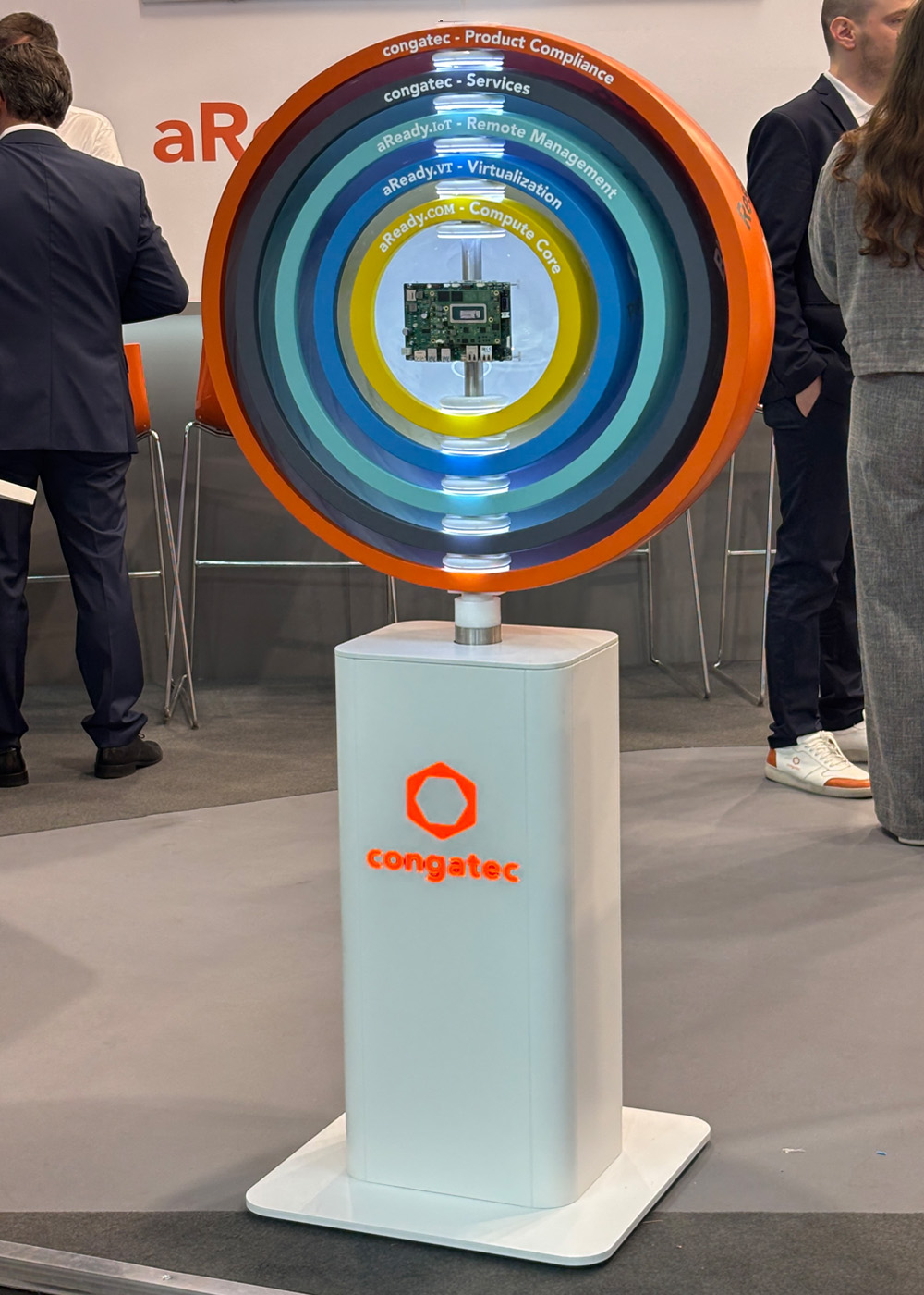 Interaktiver Produktpräsenter auf dem Messestand von Congatec mit beleuchtetem Exponat zur Visualisierung des aReady-Ökosystems. Das kreisförmige Display zeigt Embedded-Computing-Lösungen und setzt die Hardware auf der embedded world aufmerksamkeitsstark in Szene.