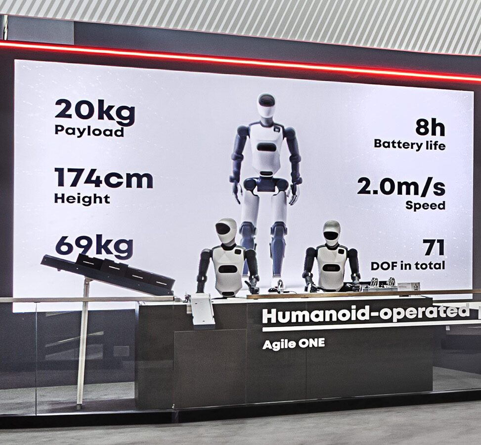 Demonstrationsfläche von Agile Robots auf der Hannover Messe mit dem humanoiden Roboter Agile ONE. Großformatige LED-Wand zeigt technische Leistungsdaten wie Traglast, Geschwindigkeit, Batterielaufzeit und Bewegungsfreiheit und unterstreicht den Fokus auf innovative Robotik und KI.