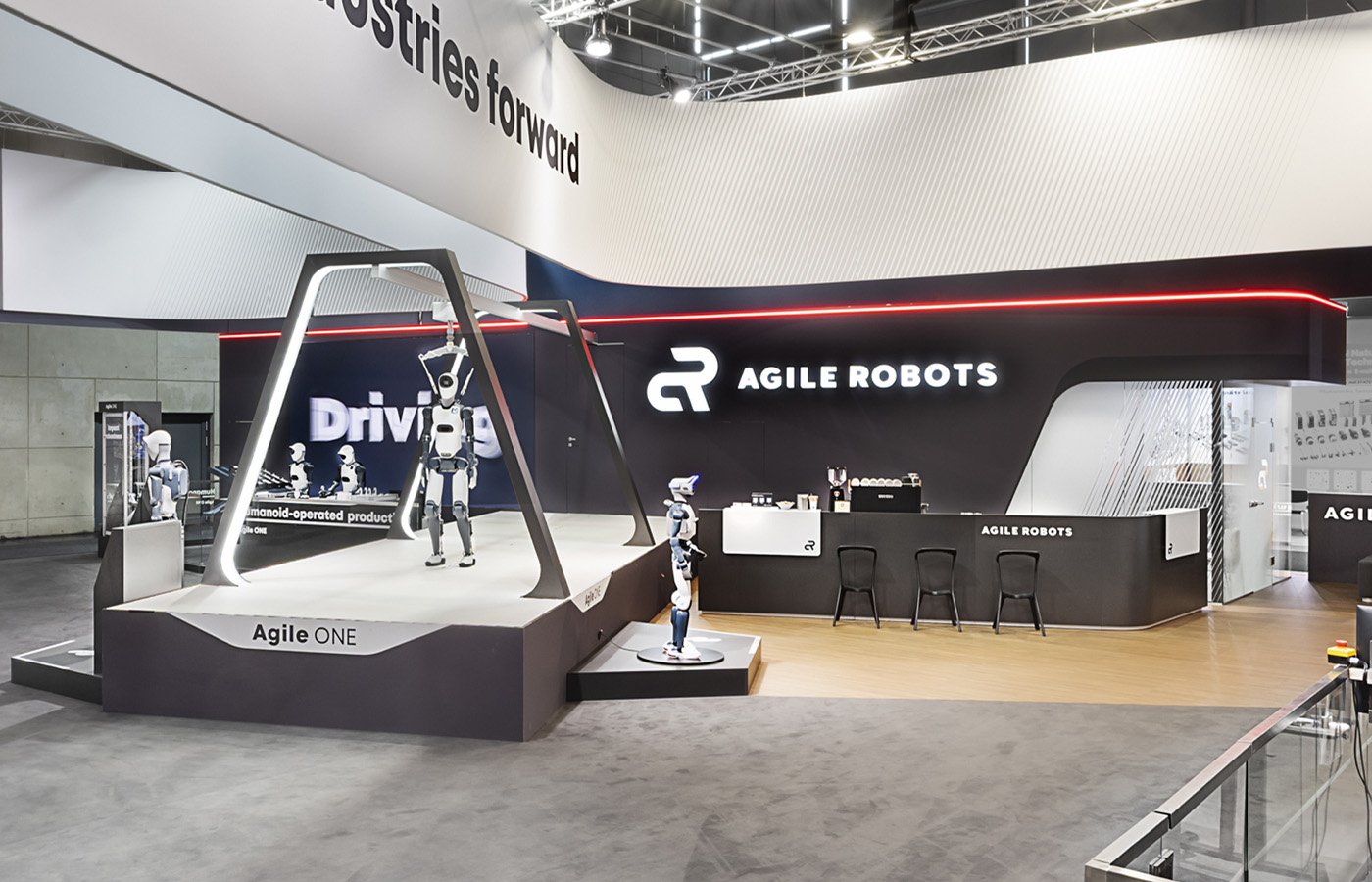 Messestand von Agile Robots auf der Hannover Messe (HMI) mit offener Standarchitektur, umlaufendem Deckenbanner und großzügigen Präsentationsflächen. Moderne Robotiklösungen, Humanoide und intelligente Automatisierungstechnologien werden in einem klar strukturierten, lichtbetonten Markenauftritt wirkungsvoll präsentiert.
