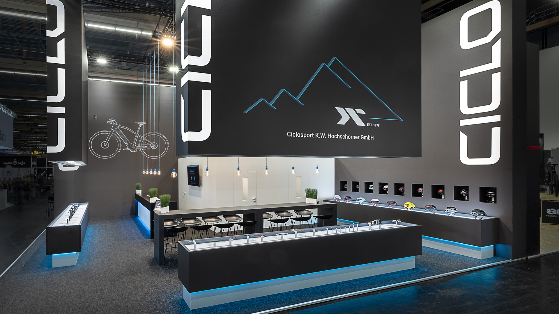 Messestand von Ciclo Sport e-Bike Components auf der Eurobike in Frankfurt mit großformatigen, abgehängten Logoelementen, beleuchteten Produktvitrinen und kontrastreichem Standdesign zur hochwertigen Präsentation von Fahrrad- und e-Bike-Komponenten.