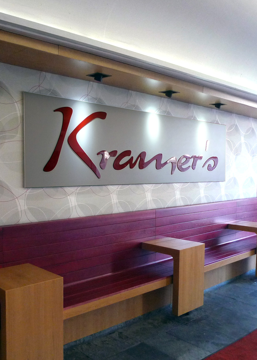 Sitzbereich mit individueller Wandgestaltung im Café- und Convenience-Store Kramer's in Salzburg und Innsbruck.