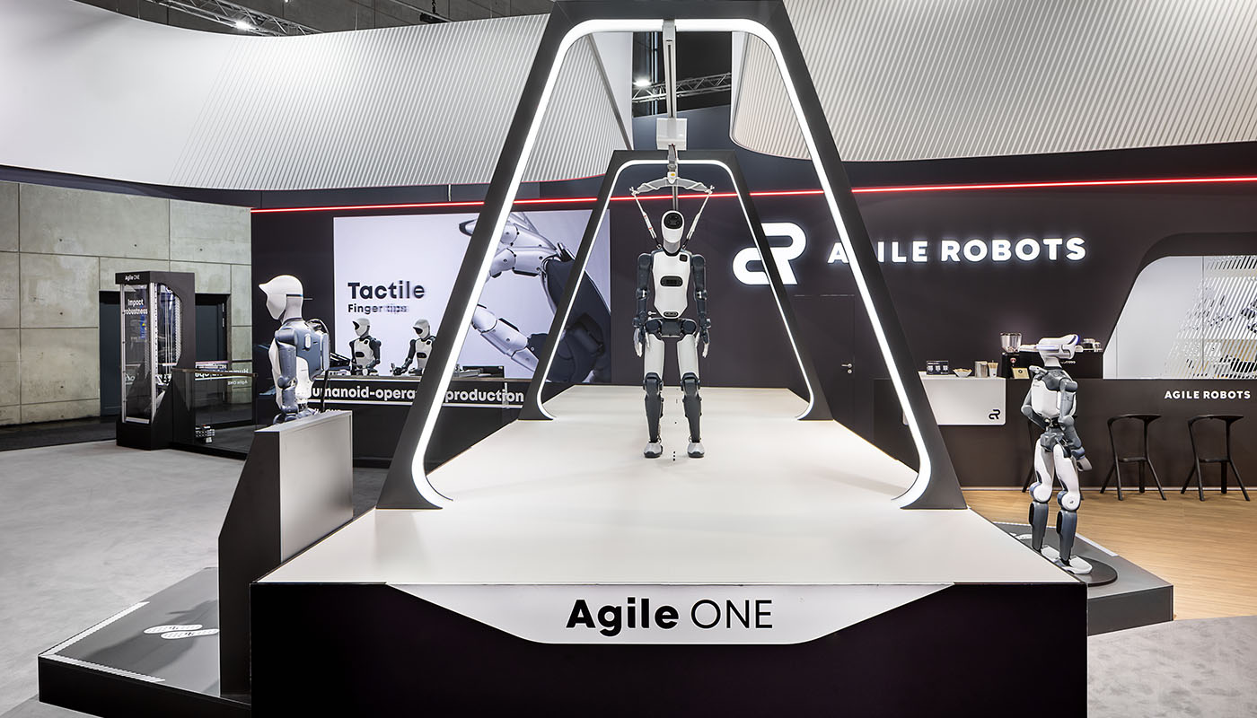 Agile ONE Live Demonstration at the Agile Robots booth at the Hannover Messe: A central catwalk with an illuminated portal showcases the humanoid robot in a modern, high-tech setting, offering an impressive hands-on experience of robotics and industrial automation.