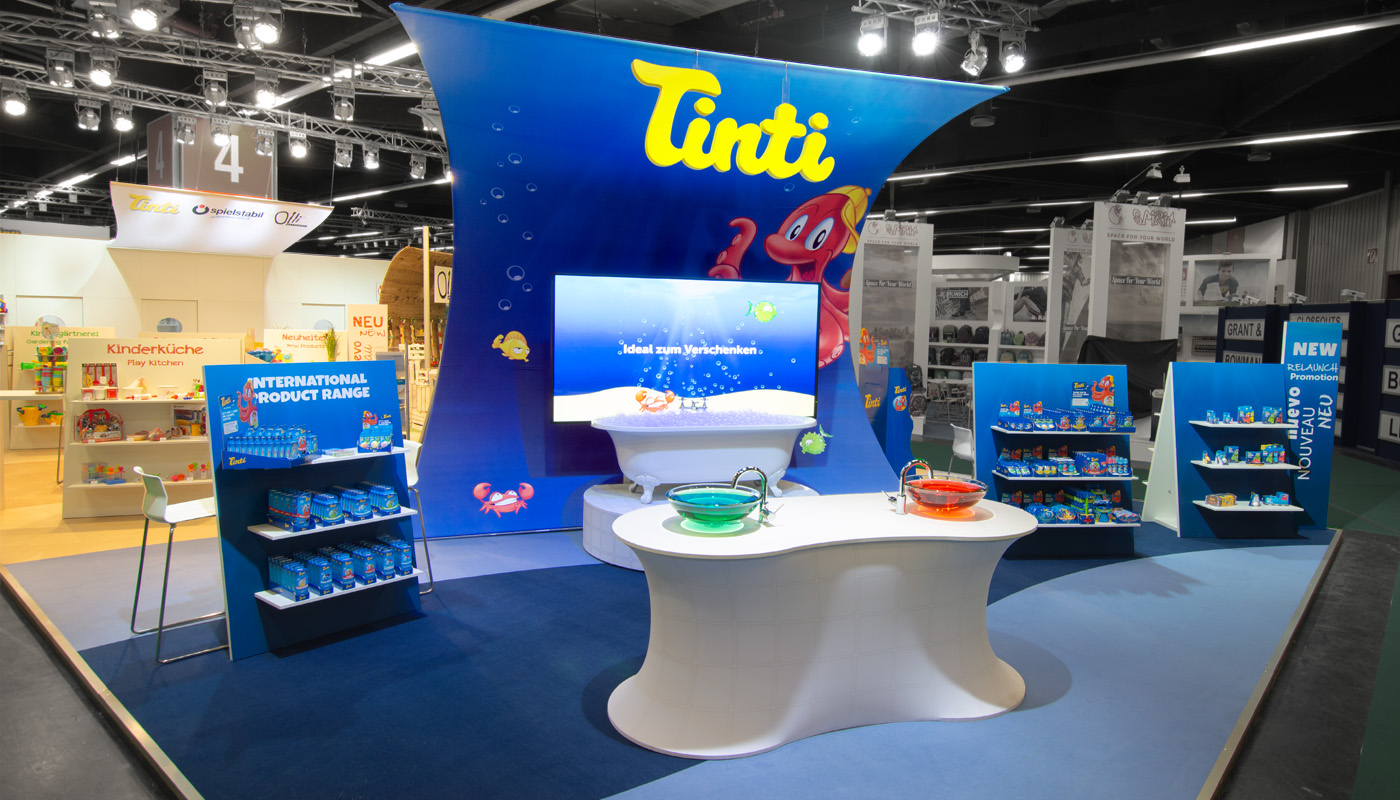 Exhibition booth for the Tinti, Spielstabil, and Olli Olbot brands at the Nuremberg Toy Fair. A sustainable exhibition concept featuring large-scale fabric architecture, interactive product presentations, and custom-designed brand experiences for children’s and educational toys.