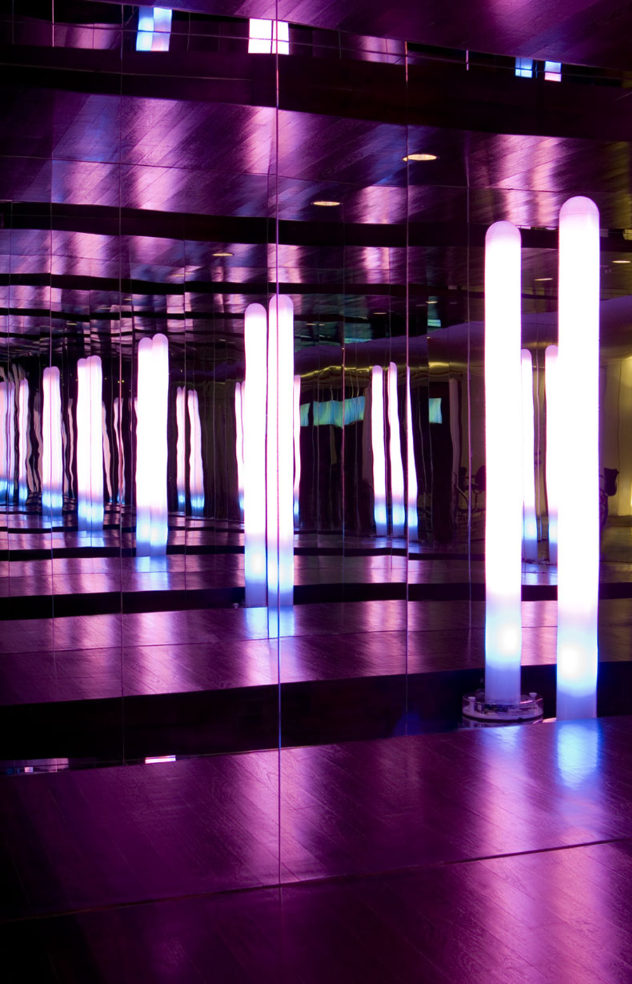 Spiegelwand mit beleuchteten Lichtstelen und atmosphärischer Lichtinszenierung in einer modernen Büroetage in New York – hochwertige Innenarchitektur mit exklusivem Design.